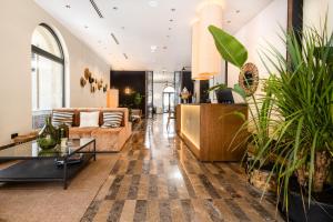 a living room with a couch and some potted plants at Infinity Hotel & More in Budva