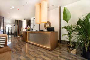 a lobby with a reception desk and potted plants at Infinity Hotel & More in Budva