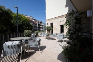 a patio with chairs and tables and a building at Infinity Hotel & More in Budva