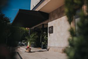 a building with a black awning on the side of it at Infinity Hotel & More in Budva