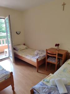 a room with two beds and a table and a mirror at Rooms Zdravko and Nevenka Cilic in Međugorje +90 photos