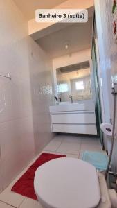 une salle de bain avec des toilettes blanches et un lavabo dans l'établissement Lindo apto de frente para o mar, à Serra 38 autres photos