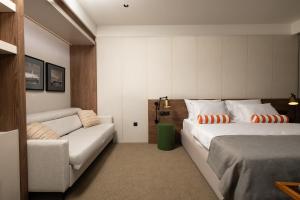 a hotel room with two beds and a couch at Infinity Hotel & More in Budva