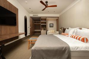 a bedroom with a large bed with a ceiling fan at Infinity Hotel & More in Budva