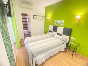 a green bedroom with a bed and a green wall at Hostal Fabiola in Seville