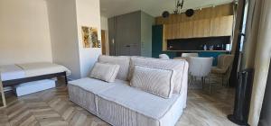 a living room with a couch and a dining room at Home Factory Ghandiego in Łódź +2 photos