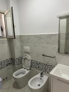 a white bathroom with a toilet and a sink at Hotel De La Playa in Velipojë +9 photos