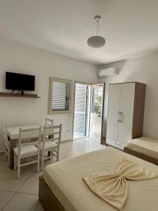 a bedroom with a bed and a table and a tv at Hotel De La Playa in Velipojë