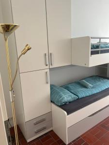 Cette petite chambre blanche comprend un lit et une lampe. dans l'établissement Seeblick Bodensee 6 Free parking Free internet, à Bregenz