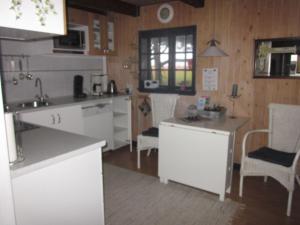 ヴィデ・サンデにあるApartment Holmslandのキッチン(白いカウンター、白いキャビネット付)