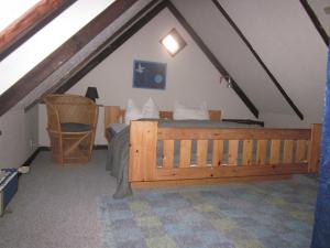 a bedroom with a wooden bed in a attic at Apartment Holmsland in Hvide Sande