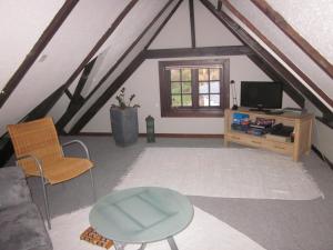 a living room with a couch and a tv at Apartment Holmsland in Hvide Sande +4 photos