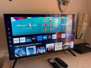 Un televisor de pantalla plana sobre una mesa con dos controles remotos. en Villetta La Risacca, en Costa Paradiso