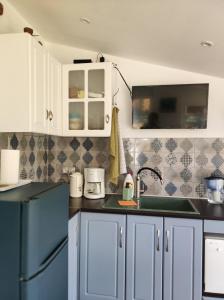 eine Küche mit weißen Schränken und einem blauen Kühlschrank in der Unterkunft Vintage House Prima Priori in Vaklino