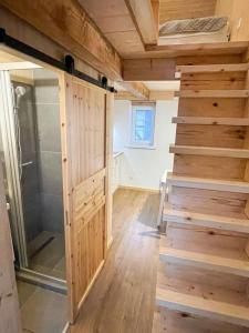 a room with a walk in shower and wooden stairs at Pamario studija in Nida +7 photos