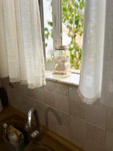 a window in a kitchen with a jar on a window sill at K7 House Κέντρο Καλαμάτας in Kalamata +49 photos