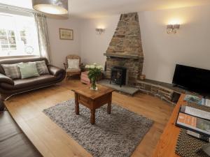 a living room with a couch and a fireplace at The Granary in Kilgetty