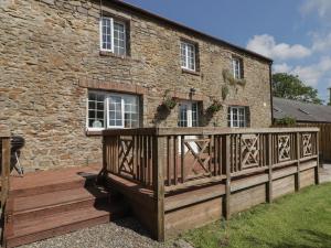 a wooden deck in front of a stone building at The Granary in Kilgetty