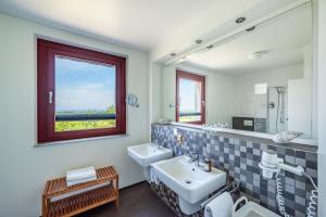 een badkamer met 2 wastafels en een raam bij Eagle mit Ostseeblick - Haus Fore zu Schloss Ranzow in Lohme