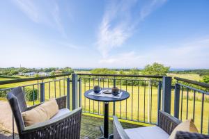 een terras met een tafel en stoelen op een balkon bij Eagle mit Ostseeblick - Haus Fore zu Schloss Ranzow in Lohme