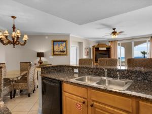 a kitchen with a sink and a table with chairs at San Remo Condominium 201 by Newman-Dailey in Santa Rosa Beach +31 photos