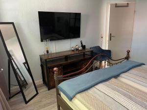 a bedroom with a bed and a television on a table at Hans im Glück in Friedrichstadt