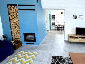 a living room with a blue wall and a fireplace at Chatka Rybaka - wygodny dom z podwórkiem in Łeba