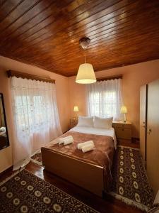 a bedroom with a large bed with two towels on it at Rustic House in Miléa