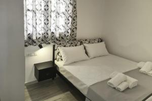 a bedroom with a bed with white sheets and a window at Mary's House 1 in Skiros