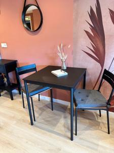 a black table with two chairs and a mirror at Overnachten bij de Haven in Lelystad