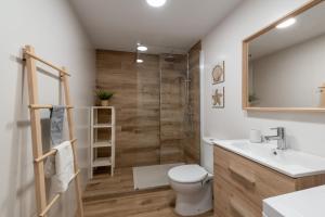 a bathroom with a toilet and a sink and a shower at Renovated apartment on beachside with pool in Nerja