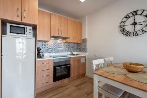 a kitchen with a table and a clock on the wall at Renovated apartment on beachside with pool in Nerja