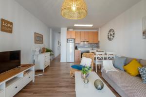 a living room with a couch and a kitchen at Renovated apartment on beachside with pool in Nerja