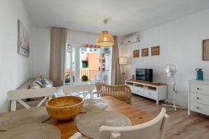 a kitchen and living room with a table and chairs at Renovated apartment on beachside with pool in Nerja