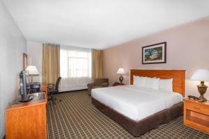a hotel room with a bed and a television at Clarion Inn & Suites Miami International Airport in Miami
