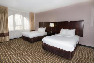 a hotel room with two beds and a window at Clarion Inn & Suites Miami International Airport in Miami