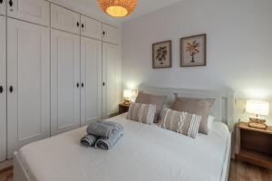 a bedroom with a white bed with two pillows at Renovated apartment on beachside with pool in Nerja