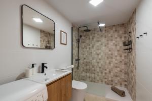 a bathroom with a sink and a toilet and a mirror at Renovated apartment on beachside with pool in Nerja