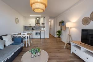 a living room and kitchen with a couch and a table at Renovated apartment on beachside with pool in Nerja