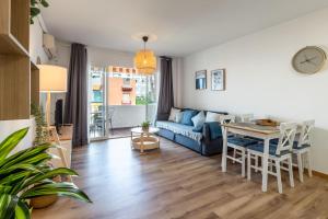 a living room with a blue couch and a table at Renovated apartment on beachside with pool in Nerja