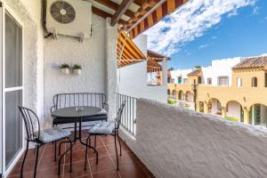 a patio with a table and chairs on a balcony at Renovated apartment on beachside with pool in Nerja