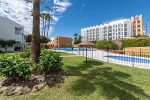 a resort with a swimming pool and a hotel at Renovated apartment on beachside with pool in Nerja