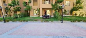 une cour d'un immeuble avec une table et un banc dans l'établissement شالية في قرية اكوا فيو الساحل الشمالي, à El Qasaba esh Sharqīya