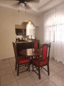 a kitchen with a wooden table and two chairs and a table and a kitchen at Twin House in San Pedro Sula