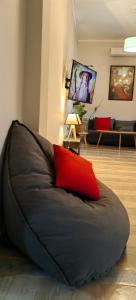 a couch with a red pillow in a living room at Allin home in Mantoúkion