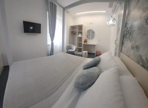 a bedroom with a large white bed with blue pillows at B&B Central Vasto in Vasto