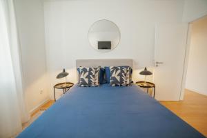 a bedroom with a blue bed with two lamps at Douro Panoramic Views by Vacationy in Bandeira