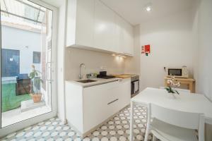 a kitchen with white cabinets and a table and a window at Douro Panoramic Views by Vacationy in Bandeira