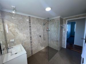 a bathroom with a shower and a sink at Ocean Retreat in Nambucca Heads