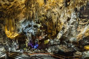 a cave with a large rock wall at Renovated apartment on beachside with pool in Nerja
